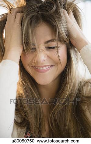 Stock Image - Young woman pulling her hair. Fotosearch