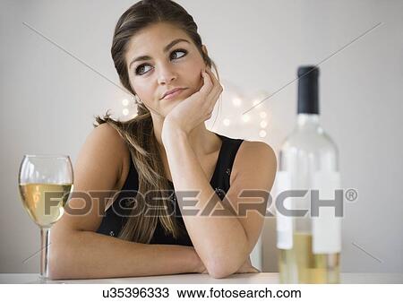 Young woman sitting at table and contemplating View Large Photo Image Stock Image - Young woman sitting at table and contemplating. Fotosearch