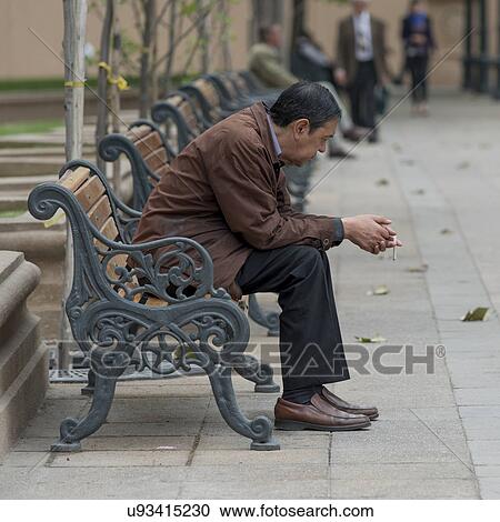 Stock Image - "Man sitting on bench, Santiago, Santiago Metropolitan Region, Chile". Fotosearch