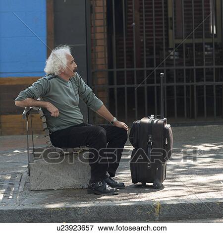 "Man sitting on bench with suitcase, Santiago, Santiago Metropolitan Region, Chile" View Large Photo Image Stock Photo - "Man sitting on bench with suitcase, Santiago, Santiago Metropolitan Region, Chile". Fotosearch
