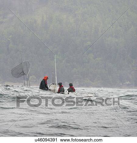 Stock Image - "View of fishermen in a boat, Skeena-Queen Charlotte Regional District, Hippa Island, Haida Gwaii, Graham Island, British Columbia, Canada". Fotosearch
