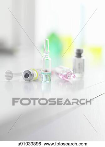 Stock Photograph - A variety of medicine and vaccines on a laboratory bench. Fotosearch