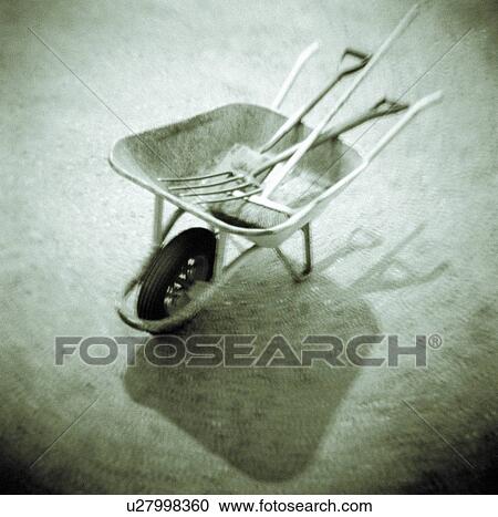 Stock Image - Art photograph of wheelbarrow with tools. Fotosearch