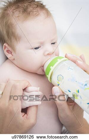Stock Photograph - Baby sucking bottle. Fotosearch