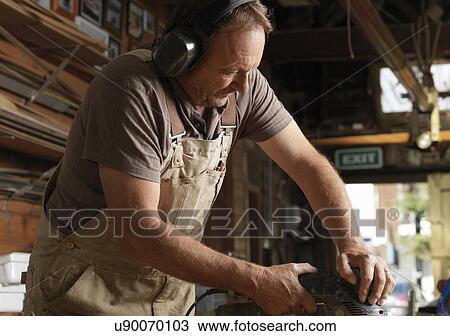 Boat builder sanding wood in workshop View Large Photo Image Stock Image - Boat builder sanding wood in workshop. Fotosearch