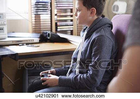 Boy using control for computer game View Large Photo Image Stock Image - Boy using control for computer game. Fotosearch