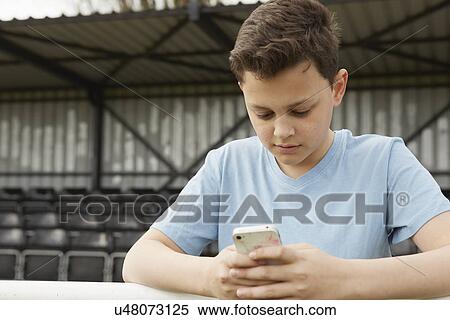 Stock Photography - Boys texting on smartphone. Fotosearch
