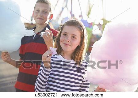 Brother and sister eating pink candyfloss at fairground View Large Photo Image Stock Image - Brother and sister eating pink candyfloss at fairground. Fotosearch