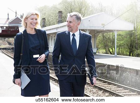 Businessman and woman talking on railway platform View Large Photo Image Picture - Businessman and woman talking on railway platform. Fotosearch