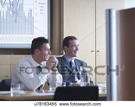 Stock Photography - "Businessmen in meeting, smiling". Fotosearch