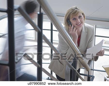 Businesswoman on phone in office stairwell View Large Photo Image Stock Image - Businesswoman on phone in office stairwell. Fotosearch