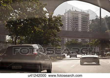 Stock Image - "Cars travelling on road, rear view". Fotosearch