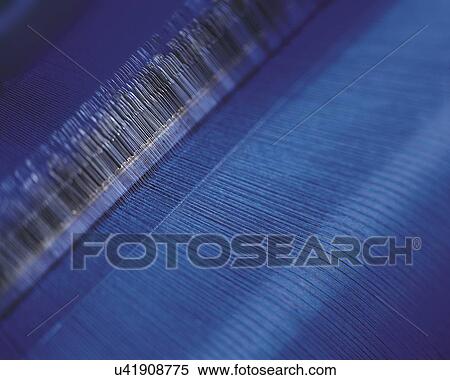 Stock Photography - Close up of blue fabric in loom. Fotosearch