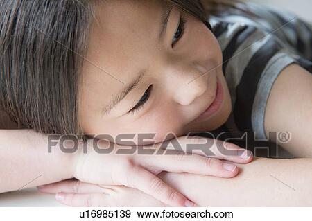 Close up of girl resting on hands View Large Photo Image Stock Photo - Close up of girl resting on hands. Fotosearch