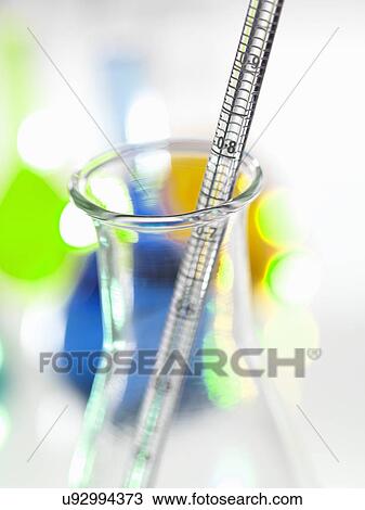 Stock Image - Close up of graduated pipette and laboratory flask. Fotosearch