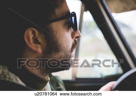 Close up of mid adult man driving and wearing sunglasses View Large Photo Image Picture - Close up of mid adult man driving and wearing sunglasses. Fotosearch