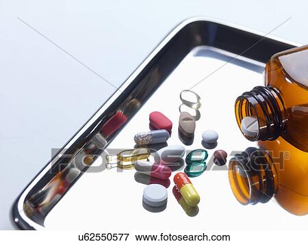 Close up of variety of medical drugs pouring from pill bottle on surgical tray View Large Photo Image Stock Photo - Close up of variety of medical drugs pouring from pill bottle on surgical tray. Fotosearch