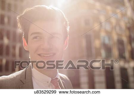 Close up of young city businessman outside sunlit office View Large Photo Image Stock Photo - Close up of young city businessman outside sunlit office. Fotosearch