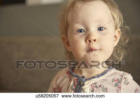 Stock Photo - Close up portrait of cute female toddler pulling a face. Fotosearch