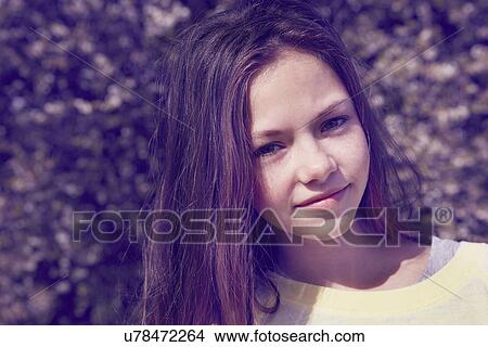 Picture - Close up portrait of girl in front of foliage. Fotosearch