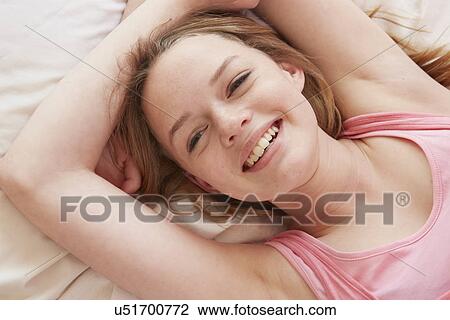 Close up portrait of girl lying on bed View Large Photo Image Stock Image - Close up portrait of girl lying on bed. Fotosearch