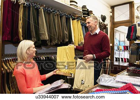 Couple browsing trousers in tailors shop View Large Photo Image Stock Photo - Couple browsing trousers in tailors shop. Fotosearch