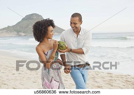 "Couple drinking coconut milk on beach, Rio De Janeiro, Brazil" View Large Photo Image Stock Photograph - "Couple drinking coconut milk on beach, Rio De Janeiro, Brazil". Fotosearch