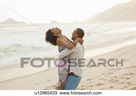 "Couple hugging on beach, Rio De Janeiro, Brazil" View Large Photo Image Stock Image - "Couple hugging on beach, Rio De Janeiro, Brazil". Fotosearch