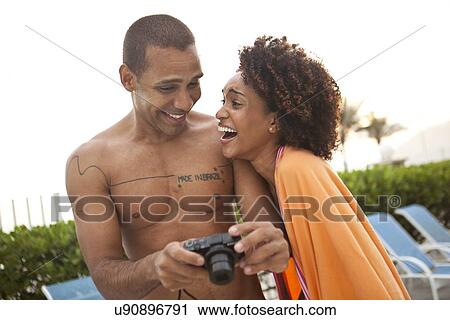 "Couple laughing at photographs on digital camera at hotel poolside, Rio De Janeiro, Brazil" View Large Photo Image Stock Image - "Couple laughing at photographs on digital camera at hotel poolside, Rio De Janeiro, Brazil". Fotosearch