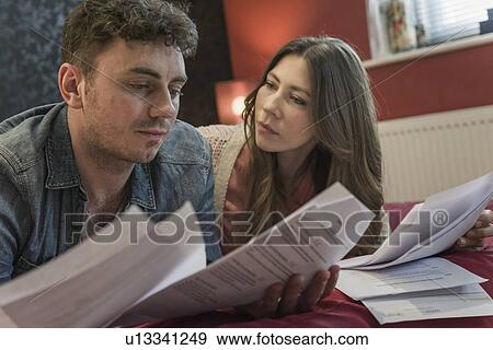 Couple looking at paperwork View Large Photo Image Stock Photo - Couple looking at paperwork. Fotosearch