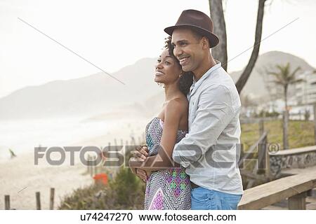 Stock Image - "Couple looking out over beach, Rio De Janeiro, Brazil". Fotosearch