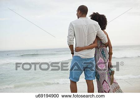 "Couple looking out to sea from beach, Rio De Janeiro, Brazil" View Large Photo Image Stock Image - "Couple looking out to sea from beach, Rio De Janeiro, Brazil". Fotosearch