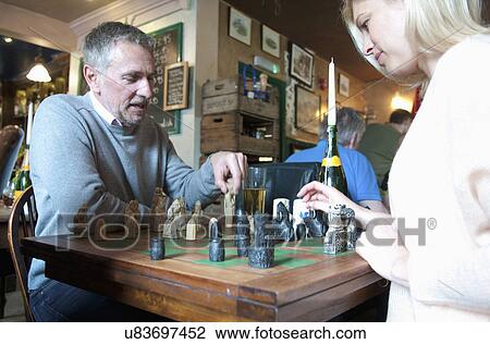 Couple playing chess in pub View Large Photo Image Stock Image - Couple playing chess in pub. Fotosearch