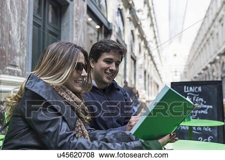 Stock Photo - "Couple reading lunch menu in Galeries Royales Saint-Hubert, Brussels, Flanders, Belgium". Fotosearch