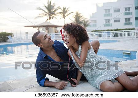 "Couple sharing headphone music at hotel poolside, Rio De Janeiro, Brazil" View Large Photo Image Stock Photo - "Couple sharing headphone music at hotel poolside, Rio De Janeiro, Brazil". Fotosearch