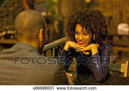 "Couple sitting at table at bar, face to face" View Large Photo Image Stock Image - "Couple sitting at table at bar, face to face". Fotosearch