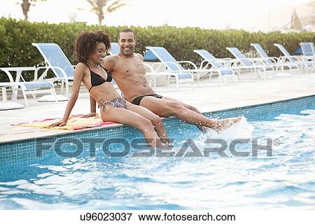 "Couple sitting splashing at hotel poolside, Rio De Janeiro, Brazil" View Large Photo Image Stock Photo - "Couple sitting splashing at hotel poolside, Rio De Janeiro, Brazil". Fotosearch