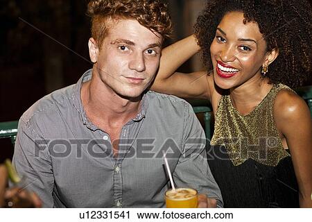 "Couple sitting together in bar, smiling" View Large Photo Image Stock Image - "Couple sitting together in bar, smiling". Fotosearch