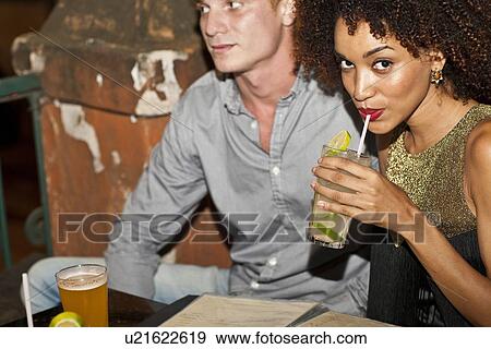 "Couple sitting together in bar, drinking" View Large Photo Image Stock Photo - "Couple sitting together in bar, drinking". Fotosearch