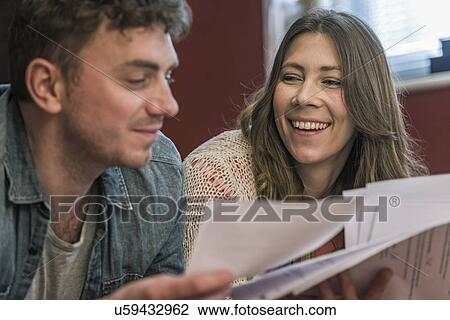 Couple smiling at paperwork View Large Photo Image Stock Image - Couple smiling at paperwork. Fotosearch