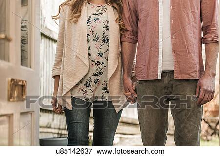 Stock Photo - Couple standing outside an open door. Fotosearch