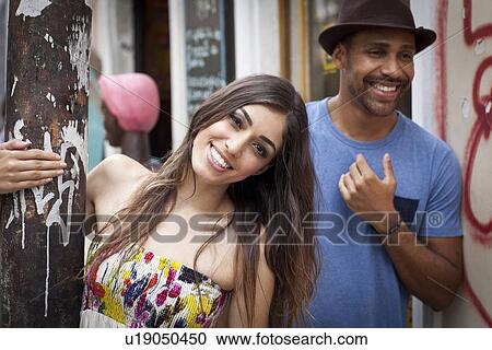 Stock Image - "Couple standing together, smiling". Fotosearch