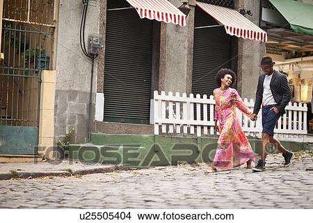 Picture - "Couple walking along cobbled street, hand in hand". Fotosearch