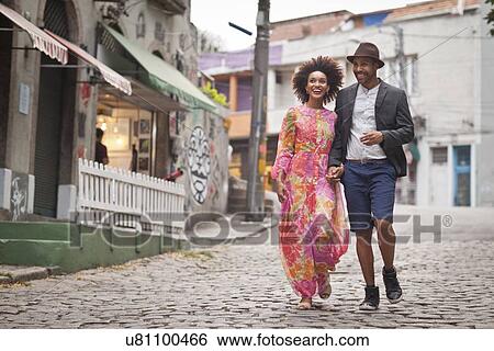 Stock Photograph - "Couple walking along cobbled street, hand in hand". Fotosearch