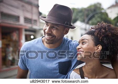 Stock Photo - "Couple walking along street, smiling, close-up". Fotosearch