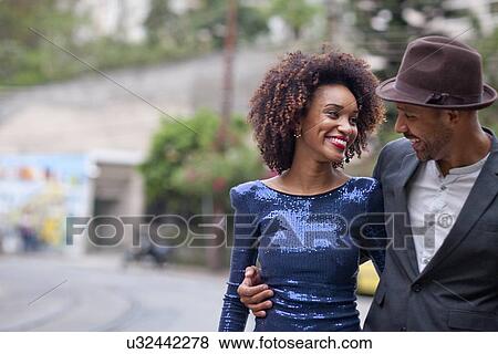 "Couple walking along street together, smiling" View Large Photo Image Stock Photo - "Couple walking along street together, smiling". Fotosearch