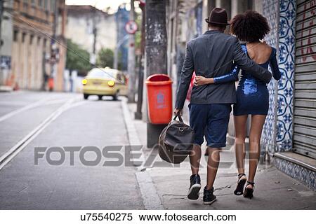Stock Photography - "Couple walking along street together, rear view". Fotosearch