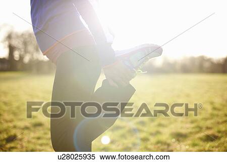 Cropped view of mature female runner stretching leg in field View Large Photo Image Stock Photography - Cropped view of mature female runner stretching leg in field. Fotosearch