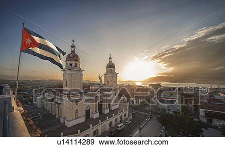 Stock Photo - "Cuban flag over Plaza de la Cathdral at sunset, Santiago de Cuba, Cuba". Fotosearch