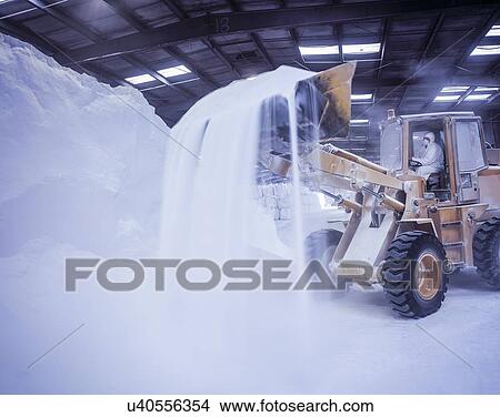 Picture - Digger loading bulk fertilizer in port. Fotosearch